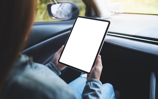 Mockup image of a woman holding and using digital tablet with blank screen in the car