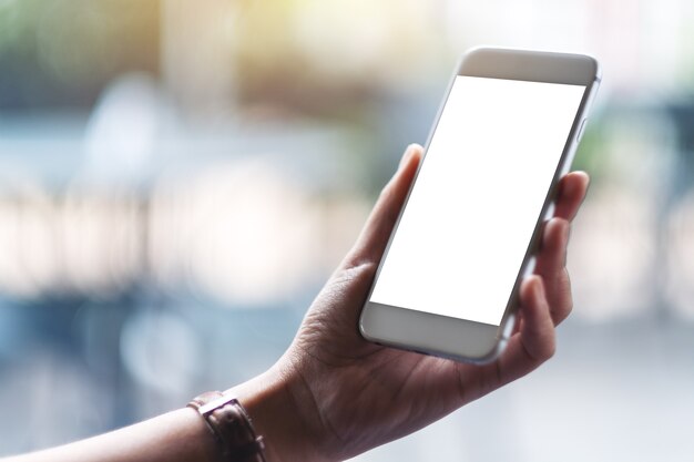 Mockup image of woman's hands holding white mobile phone with blank screen