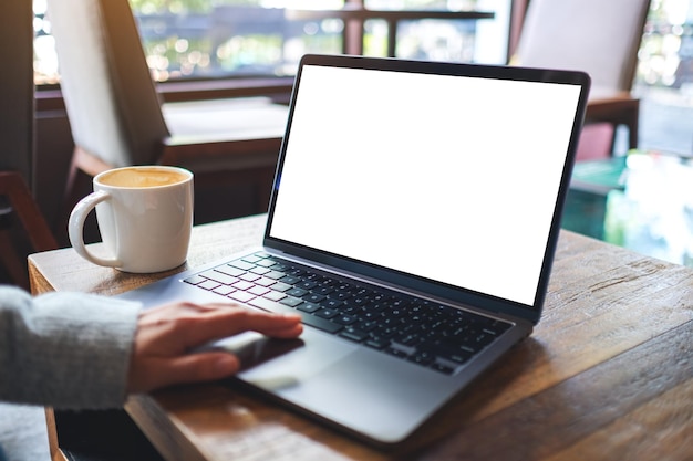 Mockup image of a woman using and touching on laptop touchpad with blank white desktop screen in cafe