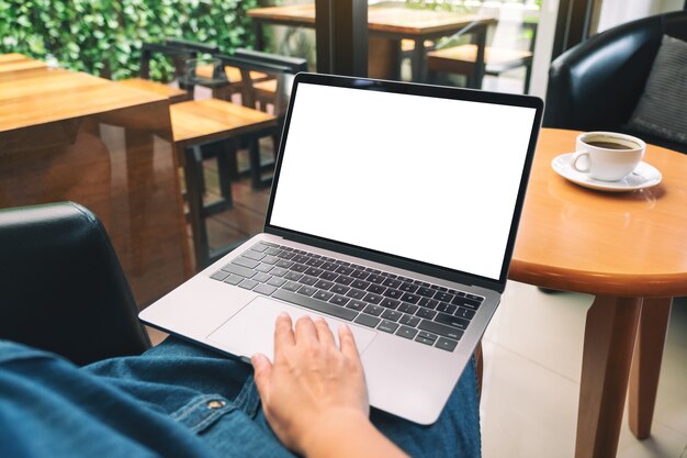 Mockup image of a woman using and touching laptop touchpad with blank white desktop screen