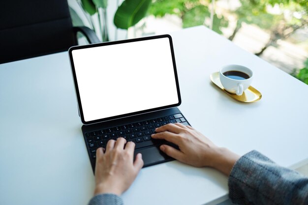 Mockup image of a woman using and typing on tablet keyboard with blank white desktop screen as a computer pc in the office