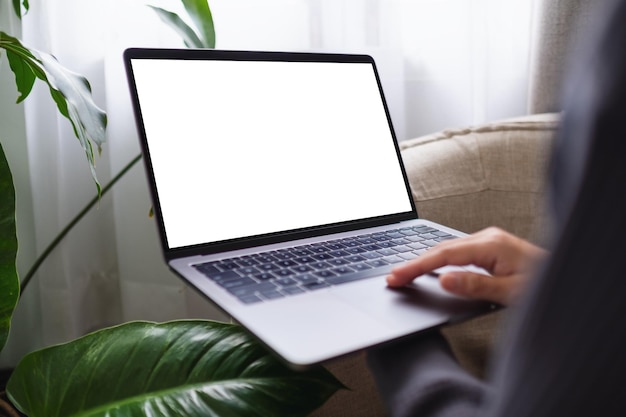 Mockup image of a woman using and working on laptop computer with blank white desktop screen at home