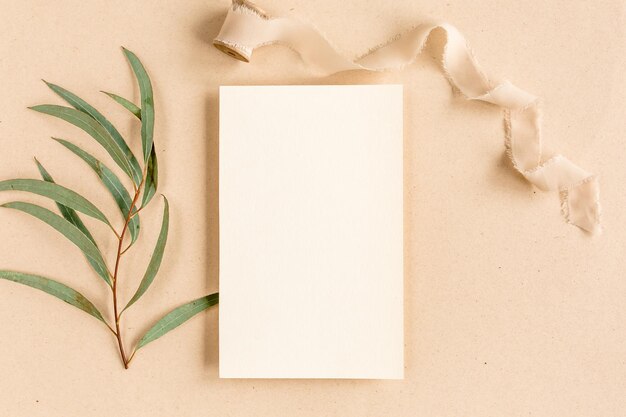 Photo mockup invitation blank greeting card and green leaves eucalyptus flat lay top view