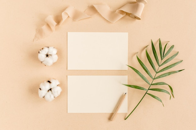 Mockup invitation blank greeting card and tropical palm leaves flat lay top view