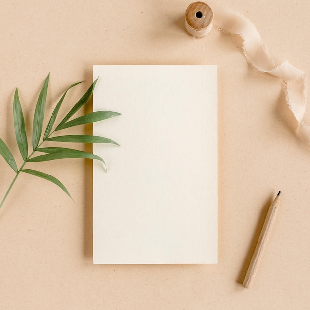 Photo mockup invitation blank greeting card and tropical palm leaves flat lay top view