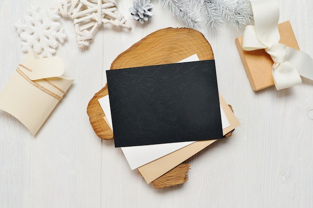 Mockup Kerst zwarte wenskaart brief in envelop en cadeau met witte boom