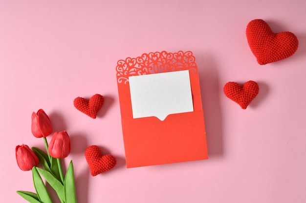 A mockup of a kraft envelope with a blank sheet tulips and knitted hearts
