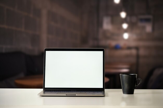 Mockup Laptop Computer and Coffee on cafe at night time.