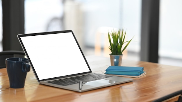 Photo mockup laptop computer empty screen on wooden table.