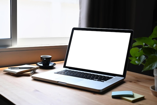 Mockup laptop computer sticky notes potted plant and coffee cup on wooden table