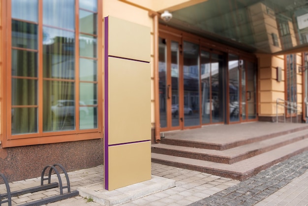 Mockup a large sign in front of a yellow building indicating the entrance parking