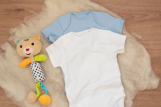 사진 다채로운 장난감과 함께 목재 배경에  ⁇ 색 아기 바디수트의 모 ⁇  빈 아기 옷 템플릿