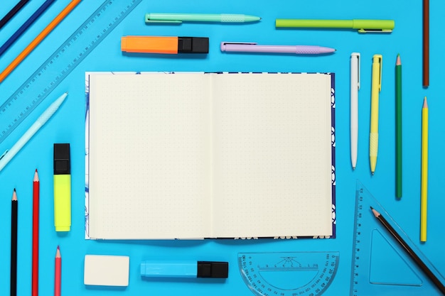 Mockup Open notebook with space for text with colorful school supplies