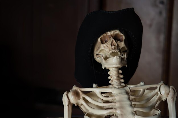 Photo a mockup of a skeleton in a hat on a dark background with a place for an inscription