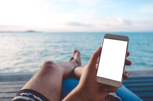 Mockup smart phone with people hand by the sea