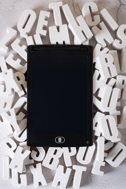 Mockup tablet among threedimensional letters made of plaster Concept of training presentations