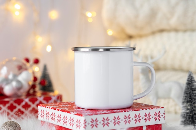 Photo mockup of trendy for branding white enamel camping cup with stainless steel ring standing over xmas