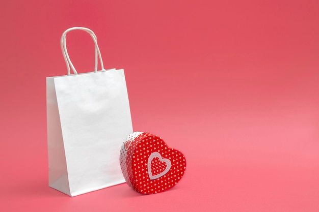 Mockup van ambachtelijke witte tas en hartvormige geschenkdoos geïsoleerd op een witte achtergrond. Handelsidee, verkoop. Detailopname