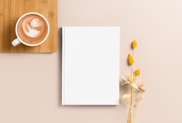 Mockup van een wit hardcover boek op een beige achtergrond met koffie Blank sjabloon