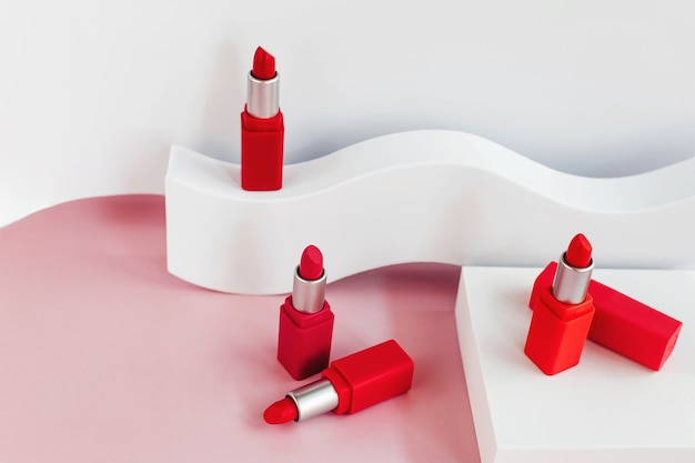 Mockup van rode lippenstift op een witte trap met geometrische vormen en een podium