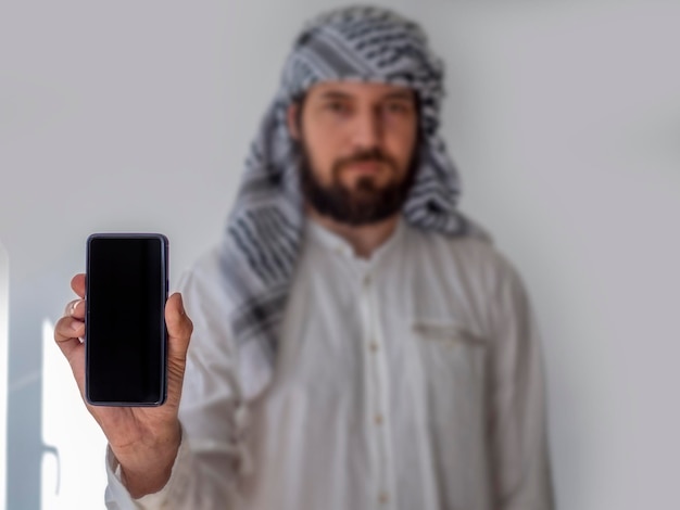 Mockup voor mobiele app of website Arabische man met smartphone met leeg scherm Vooraanzicht portret