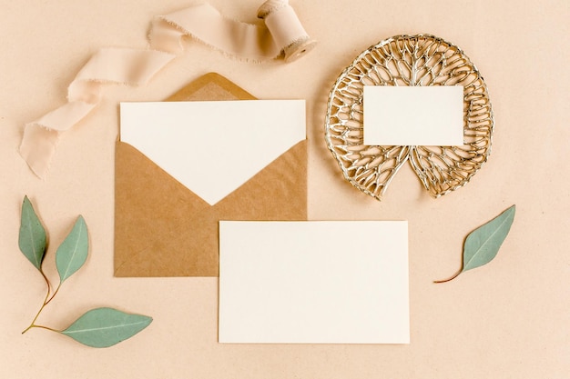 Photo mockup wedding invitation blank greeting card and craft envelope green leaves eucalyptus flat lay