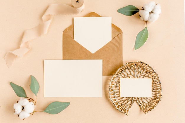 Photo mockup wedding invitation blank greeting card and craft envelope green leaves eucalyptus flat lay