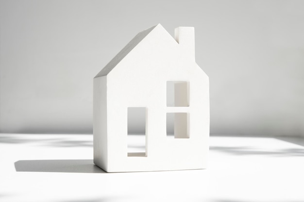 Mockup of a white house on a light gray background with a shadow the concept of buying and renting