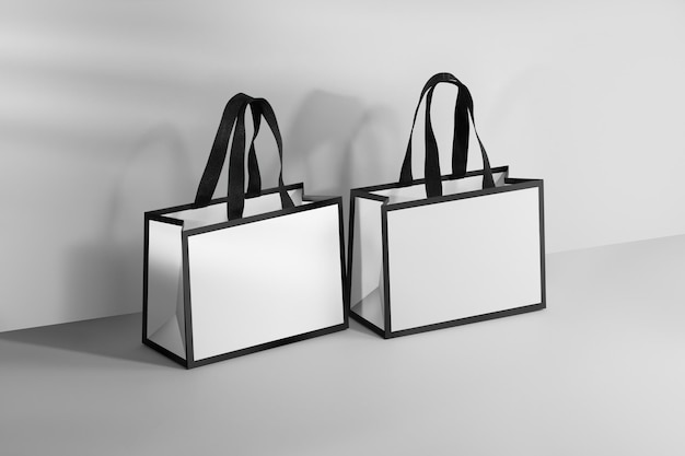 Foto mockup di una borsa di carta bianca con bordo nero e maniglie di tessuto nero