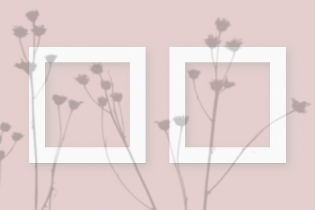 Мокап с растительными тенями, наложенными на 2 квадратных рамки из текстурированной белой бумаги на розовом фоне стола.