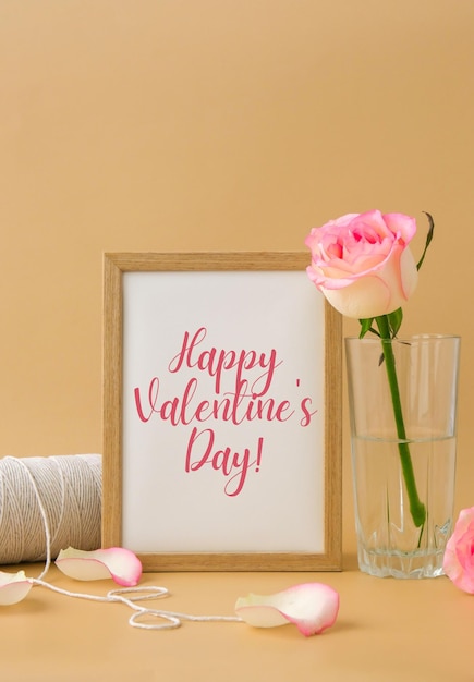Photo mockup wooden frame with text happy valentines day on delicate pink roses on beige background