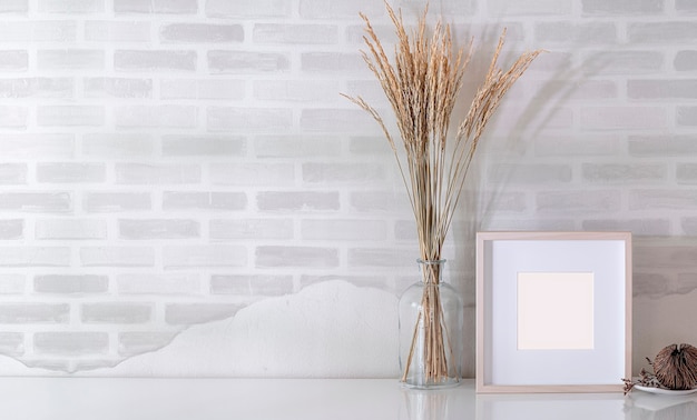 Photo mockup wooden picture frame and glass vase of plant