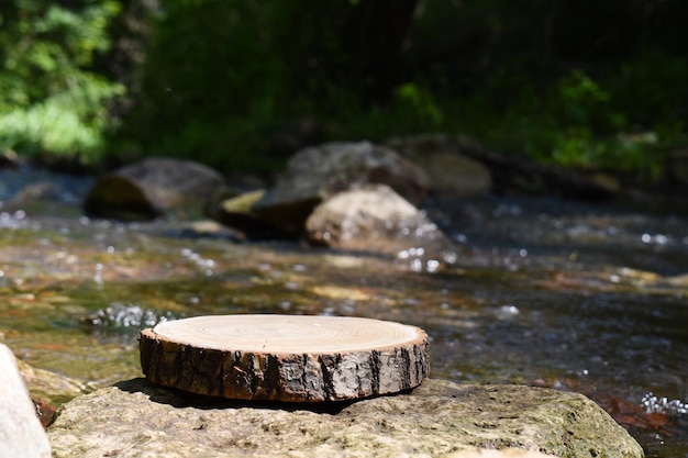 Un mockup di un podio in legno su uno sfondo sfocato di un fiume di montagna