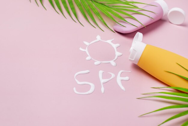 Photo mockup of yellow and pink cosmetic tube with sunscreen cream in the form of sun spf