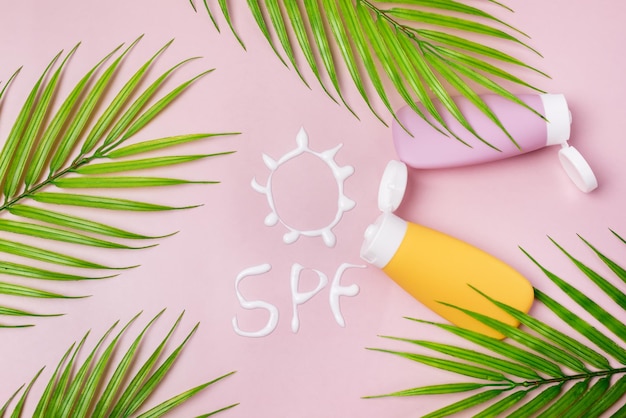 Photo mockup of yellow and pink cosmetic tube with sunscreen cream in the form of sun spf