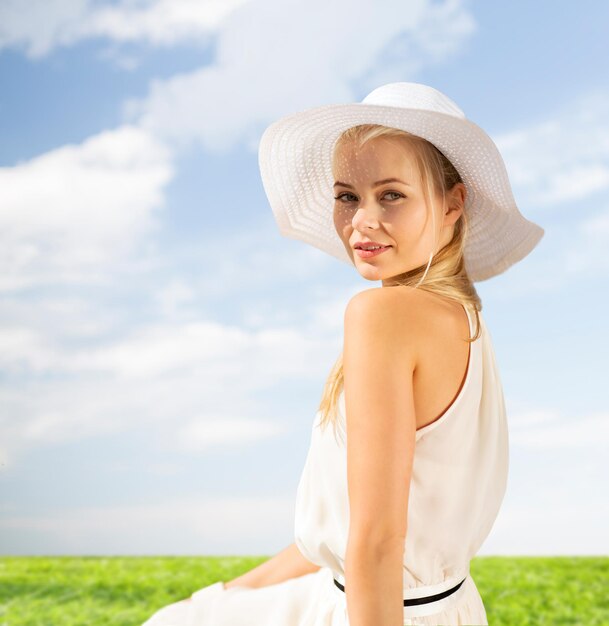 mode en lifestyle concept - mooie vrouw in hoed genieten van de zomer buiten