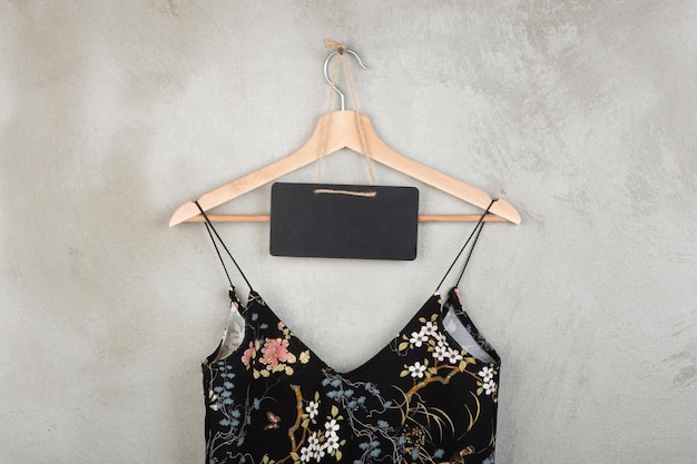 Mode en winkelconcept leeg schoolbord en mooie kleine zwarte jurk op een hanger