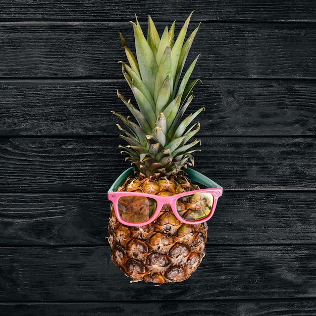 Foto mode hipster ananas fruit tropische ananas met zonnebril creatief kunstconcept bovenaanzicht vrije ruimte voor tekst