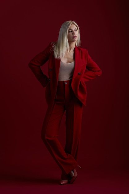 Mode jonge vrouw in rood pak rode achtergrond
