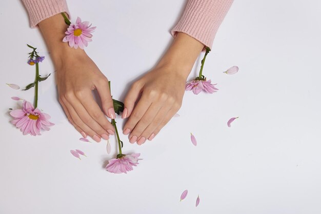 Mode kunst huidverzorging van handen en roze bloemen in handen van vrouwen