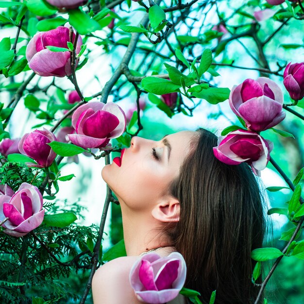 Mode lente meisje op lente magnolia bloemen achtergrond vrouw op lente bloesem background