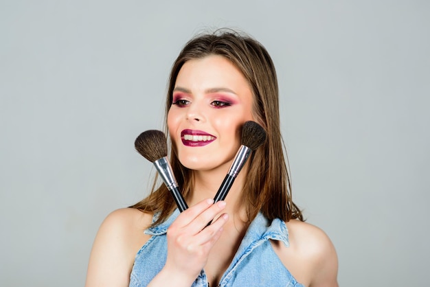 Mode make-up gezicht. sexy vrouw met professionele make-up borstel. sensuele vrouw met lang haar, stijl. schoonheid kapsalon. Lippenstift en oogschaduw. seksualiteit. huidverzorging cosmetica. Je flirterig voelen.