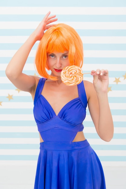 Mode meisje met oranje haar plezier Cool meisje met lolly Sexy vrouw gelukkig pinup model met lolly in de hand Gek meisje in speelse bui Gek worden Geniet van feest Zoete blik Zo veel plezier