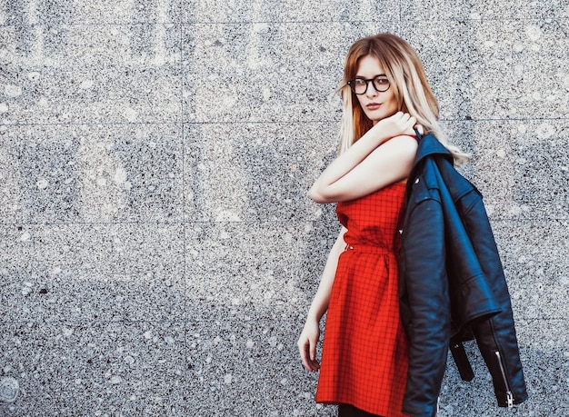 Mode portret van hipster vrouw in stijlvolle casual zomer outfit poseren tegen muur achtergrond