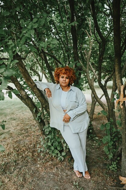 Mode portret van jonge natuurlijk mooie plus size Afro-Amerikaanse vrouw in licht broekpak