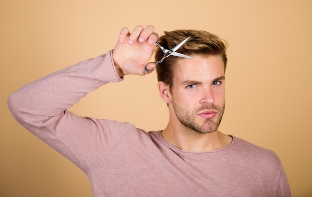 Mode portret van man mannelijke verzorging styling baard haar kapsel krijgen Kapper zelfzorg kapper werk Haarverzorging apparatuur Barbershop concept knappe man met kapper schaar