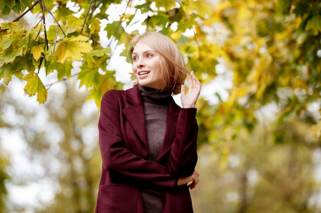 Mode portret van mooie blonde vrouw in stijlvolle kleding in herfst park.