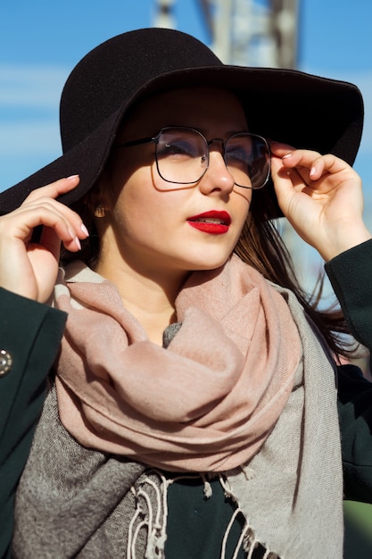 Mode portret van vrij jong model wandelen in de stad. Vrouw met modieuze hoed, sjaal en bril