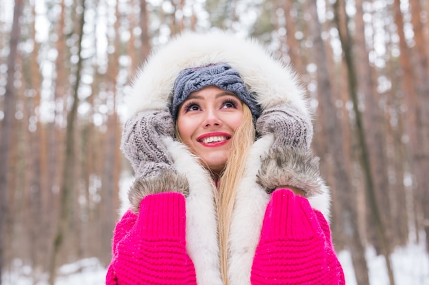 Mode schoonheid en mensen concept Portret van blonde jonge vrouw in bontjas op winter muur