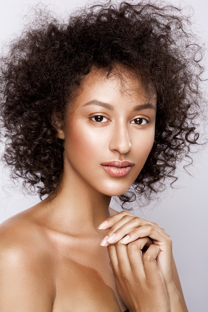 Mode studio portret van mooie Afro-Amerikaanse vrouw met perfect gladde gloeiende mulat huid, make-up